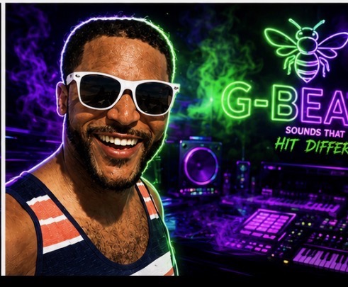 GBeats smiling in white sunglasses in his purple and green studio